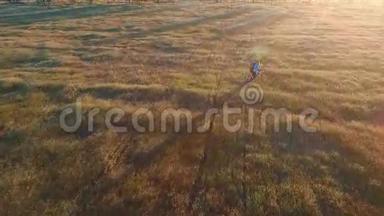 在日落的天空背景下，乡村地区的年轻女子骑自行车